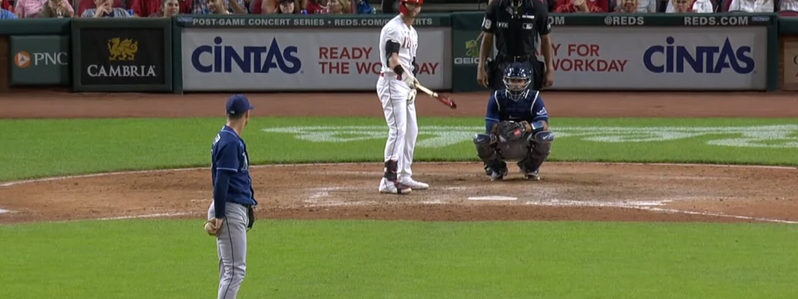 A pitcher facing a batter in a baseball game with spectators in the background