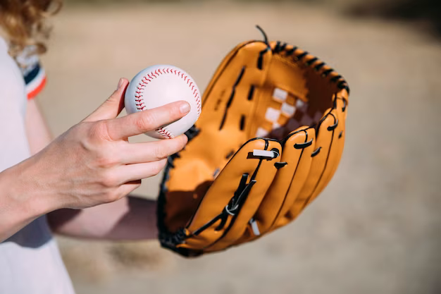 Hand holding a baseball and glove, close-up view