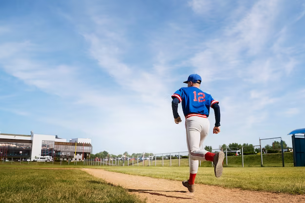 Side view of a baseball player running across the field