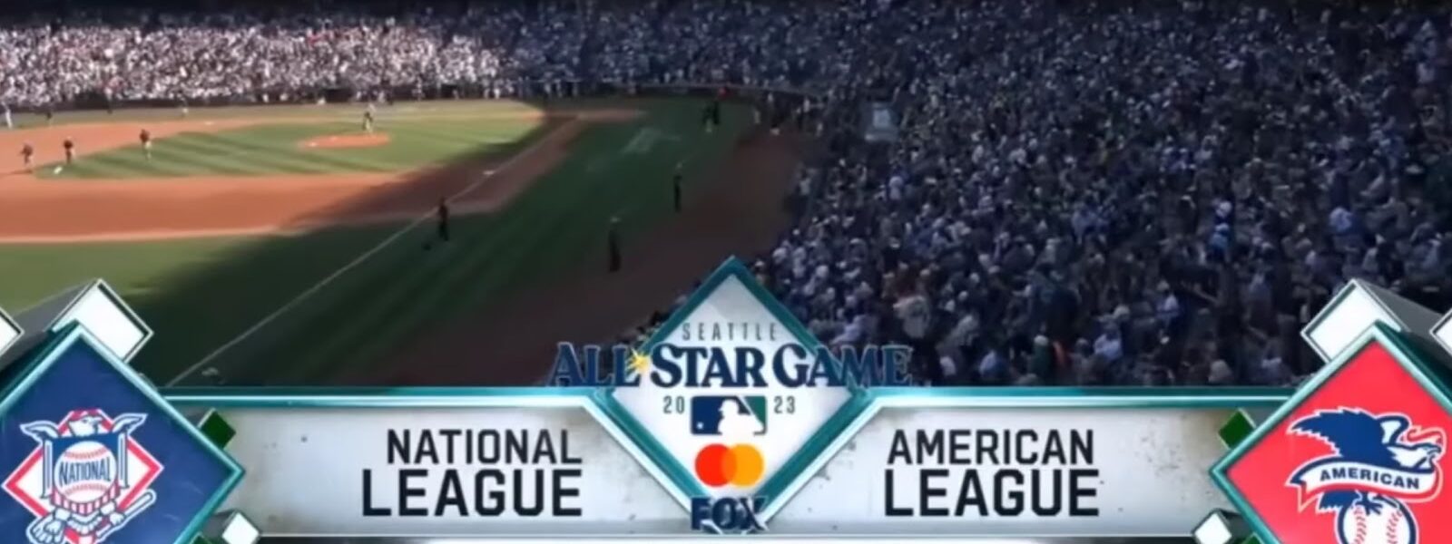 A crowded stadium in Seattle, with National and American League logos