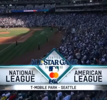 A crowded stadium in Seattle, with National and American League logos