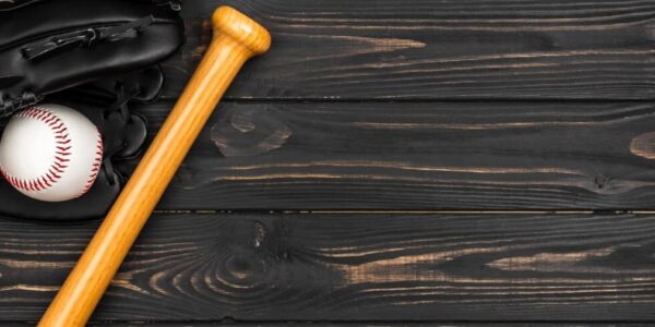 Baseball bat, glove, and ball on dark wooden background